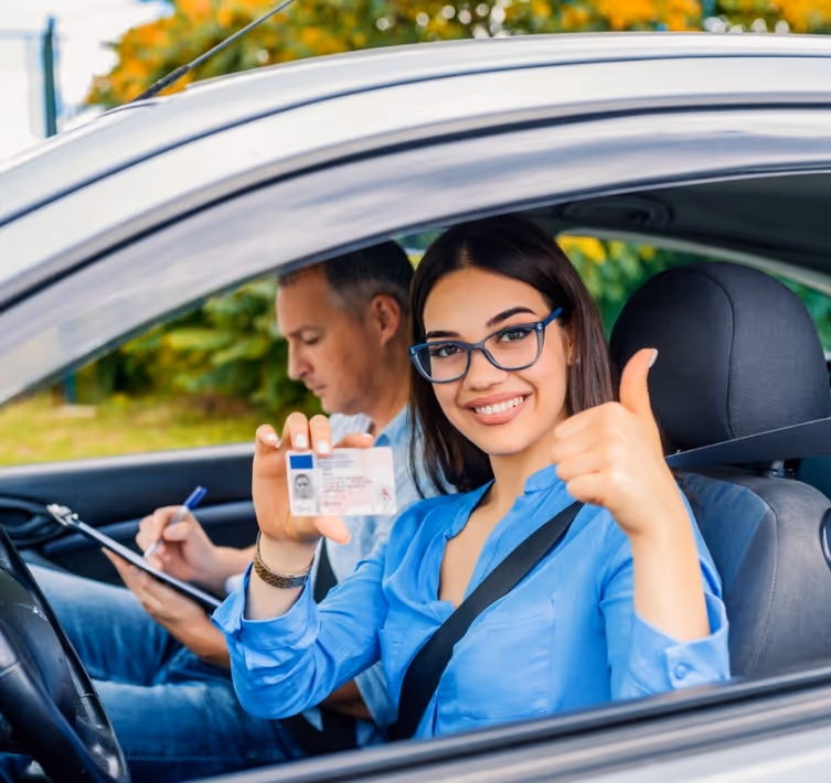 Fahrschülerin zeigt im Auto ihren Führerausweis